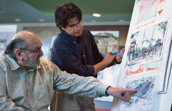 Two colleagues reviewing an architectural drawing together